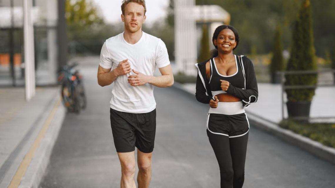 A man and woman jogging together outside, embracing a healthy lifestyle.
